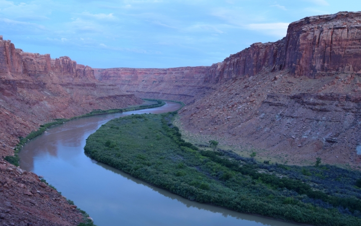 A river winds through red canyon walls at dusk